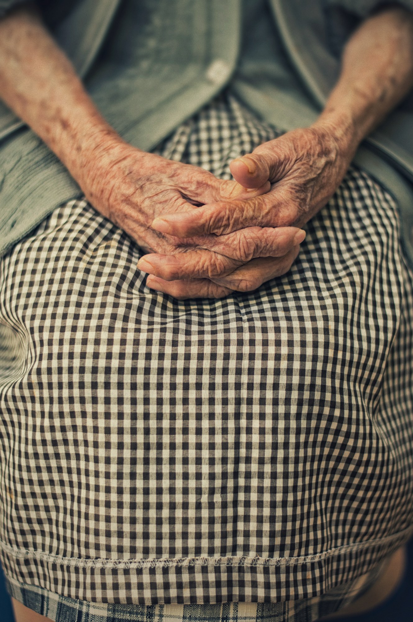 A caregiver’s hand resting over a resident’s