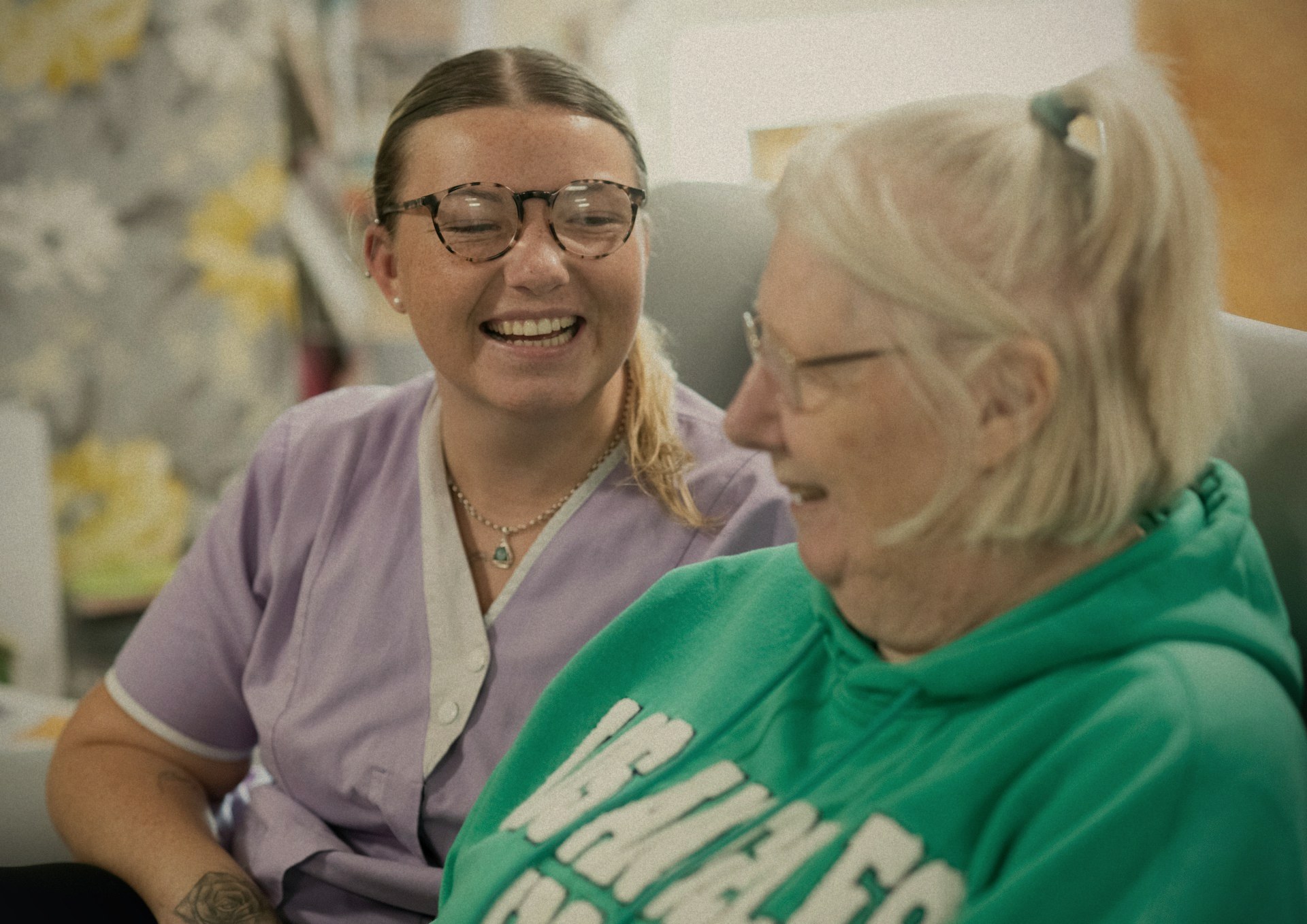 A Nurses & Company caregiver sharing a laugh with an older adult at home