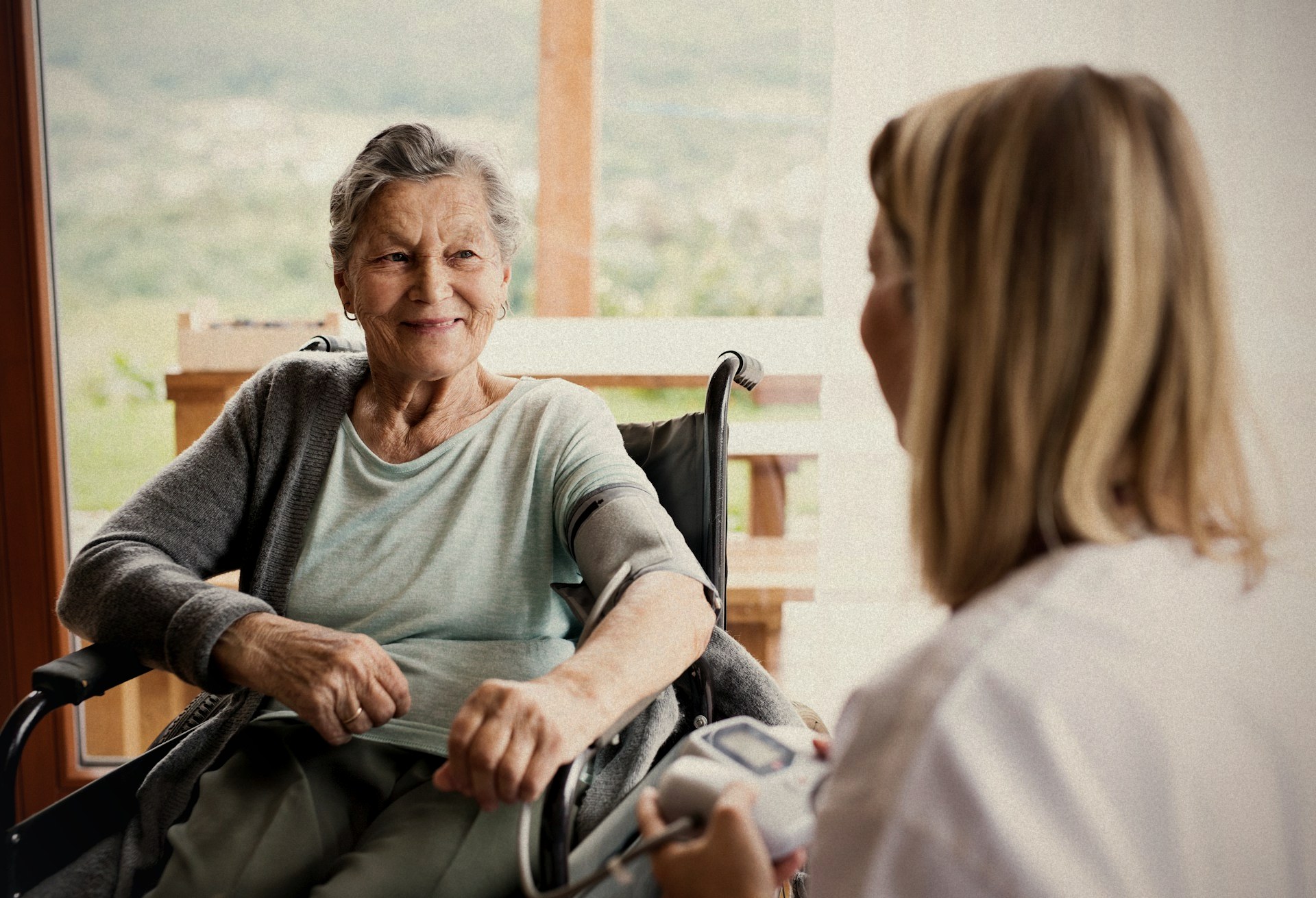 A Nurses & Company Care Manager caring for an older adult at home, by the window